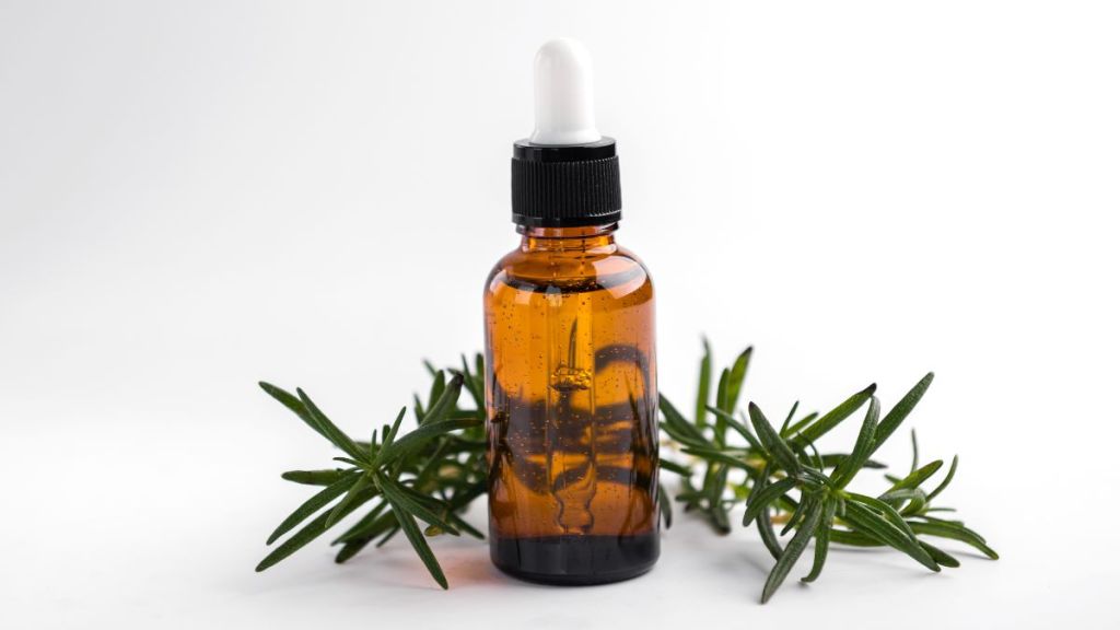 TIktok health trends: Rosemary essential oil and fresh twig on white background.