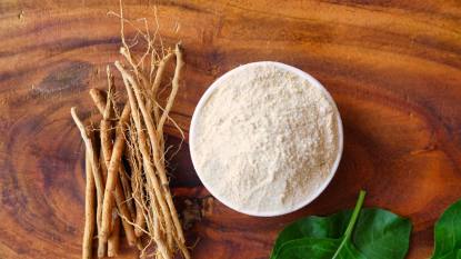 ashwagandha thyroid: Ashwagandha Roots and powder known as Withania somnifera in white bowl on wooden background. Indian ginseng, poison gooseberry, or winter cherry. Herbal adaptogen ayurvedic medicine.