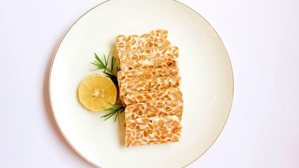 The best foods to eat for gut health: Tempeh slices on a white background