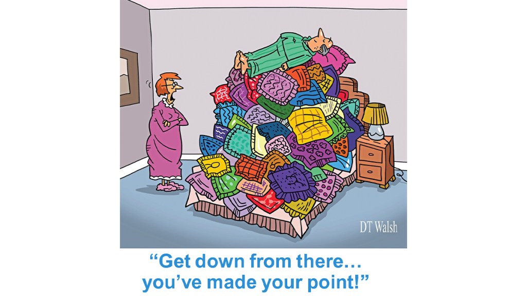 Cartoon of husband on a huge pile of throw pillows and wife saying, "Get down from there…you've made your point."