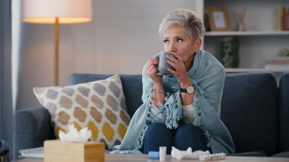 sick woman on couch drinking tea; common cold remedies that work