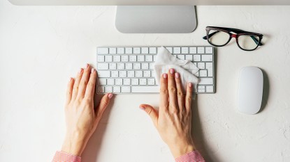 Woman wiping down a keyboard