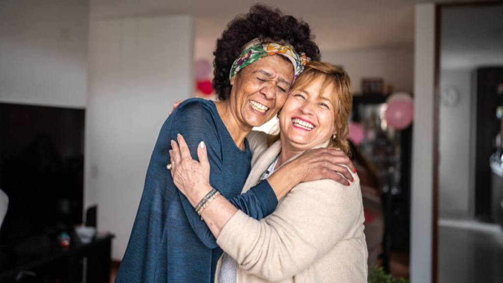 how to make friends: Portrait of senior friends embracing at home