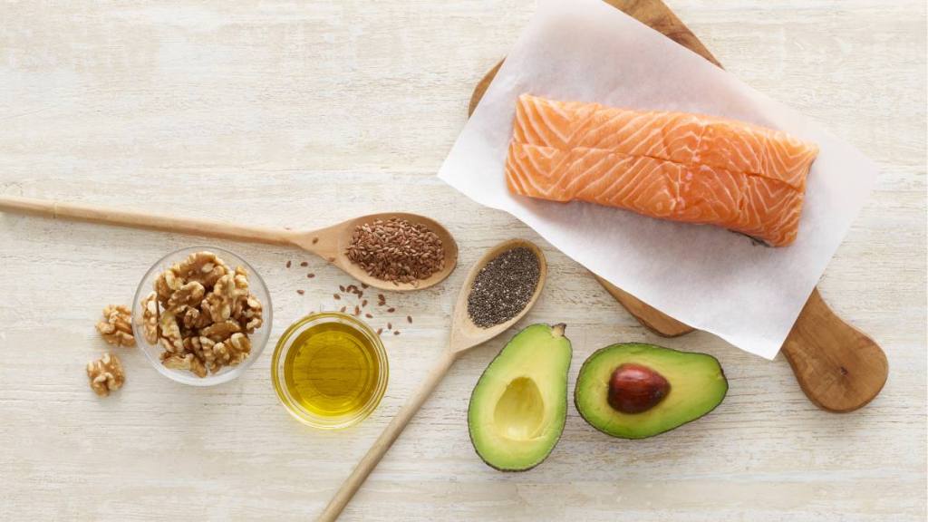 A table with fish, avocado, walnuts and chia seeds, all are which of high in omega 3s for menopause self-care