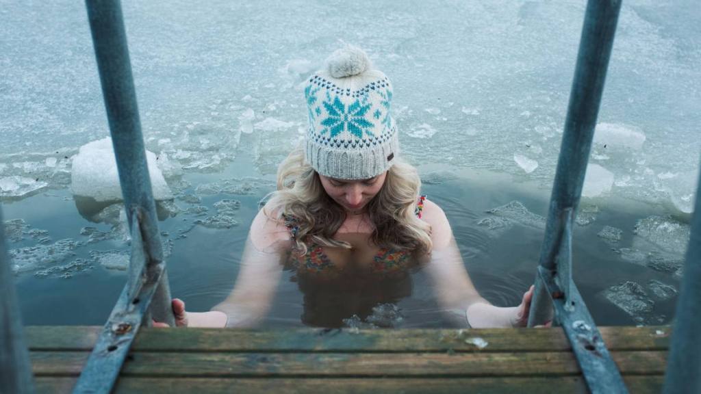 Cold plunge for menopause: Woman cold water swimming in the frozen Baltic Sea -