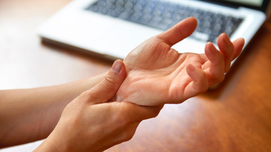 A woman rubbing her wrist as a form of carpal tunnel syndrome self-care