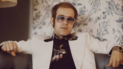 Elton John in white suit with fun glasses; Elton John greatest hits