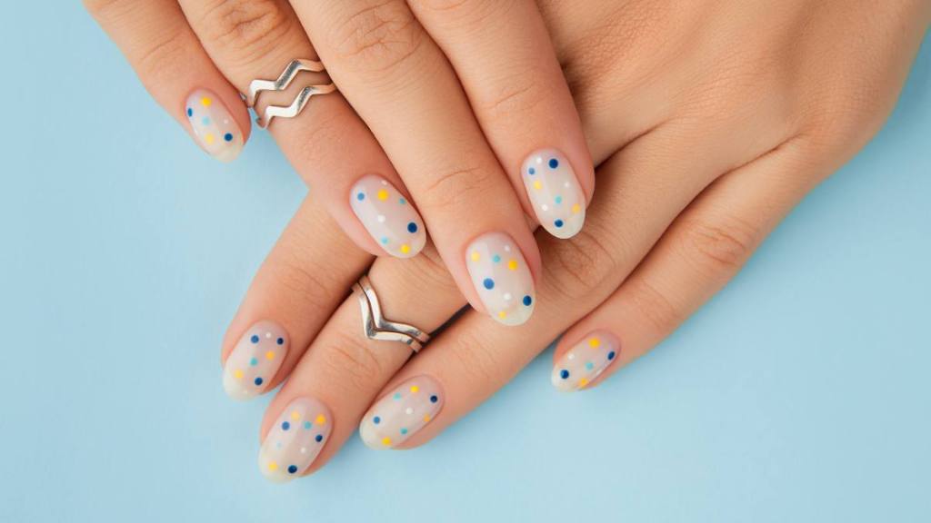 uses for pencil erasers: Womans hands with trendy polka dot summer manicure. Beauty treatment spa body care concept