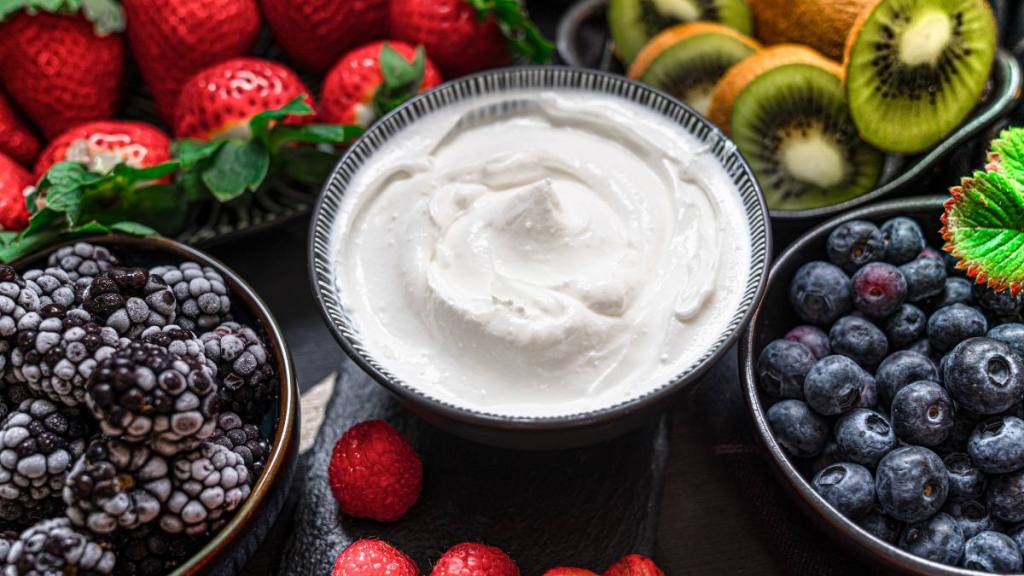 Menopause and oral health: Greek yogurt in a glass jars with spoons,Healthy breakfast with Fresh greek yogurt, muesli and berries on background.