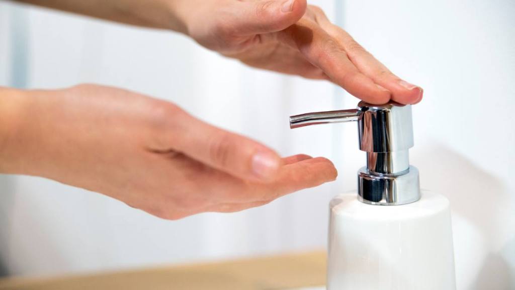 how to remove soap scum: Cosmetics daily hygiene, Female hands applying liquid soap close up 
