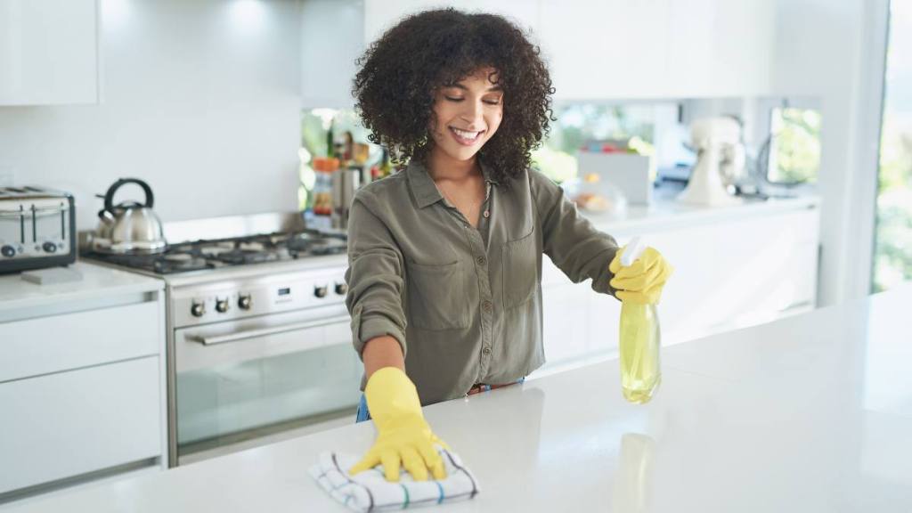 How to remove egg dye from hands:Shot of a young woman cleaning a kitchen counter at home
