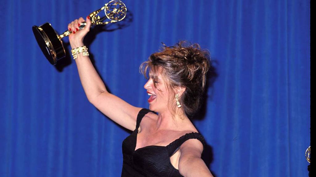 Kirstie Alley holding an award up in the air