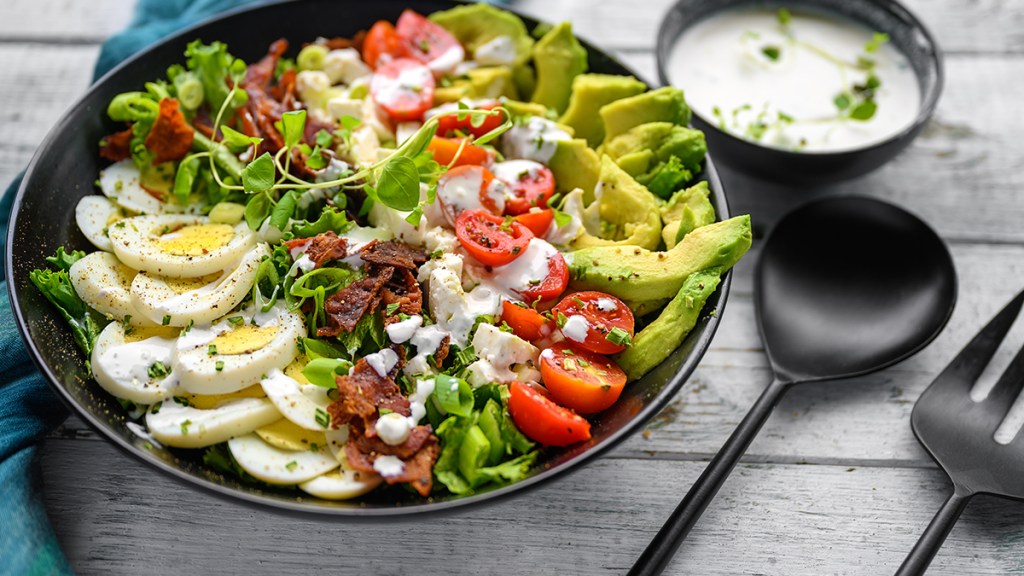keto-friendly salad with eggs, avocado, bacon, lettuce, tomagoesa and cheese; diet for fatty liver