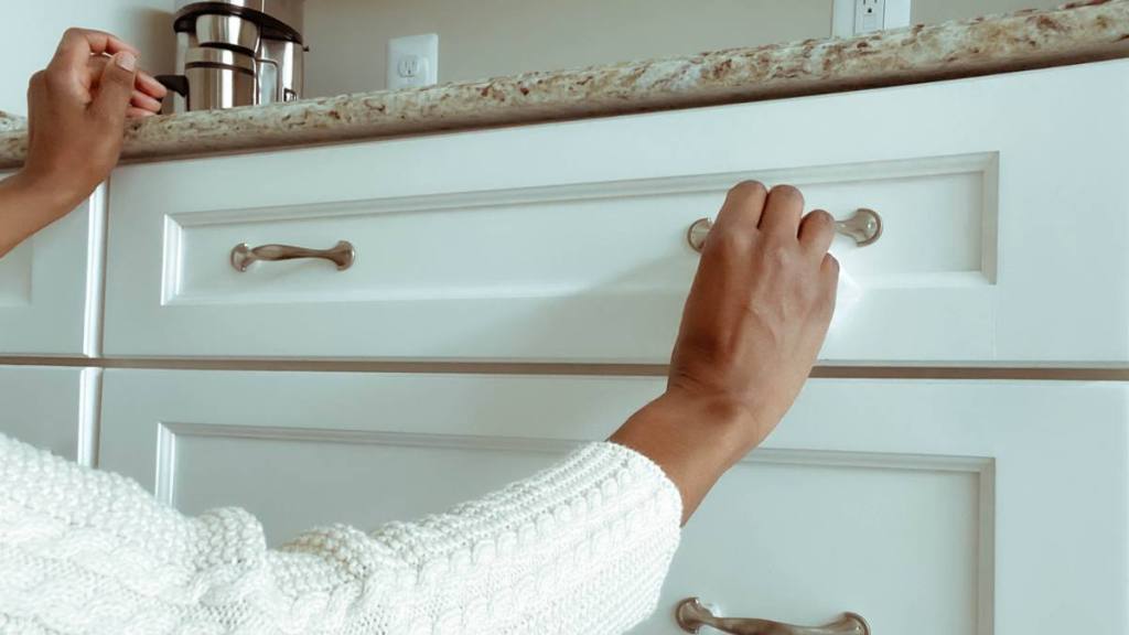 women replaces drawer knobs after learning What Not to Fix When Selling a House