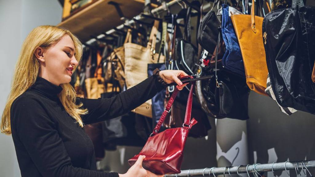 Woman shopping for handbags and knowing what to avoid at a thrift store