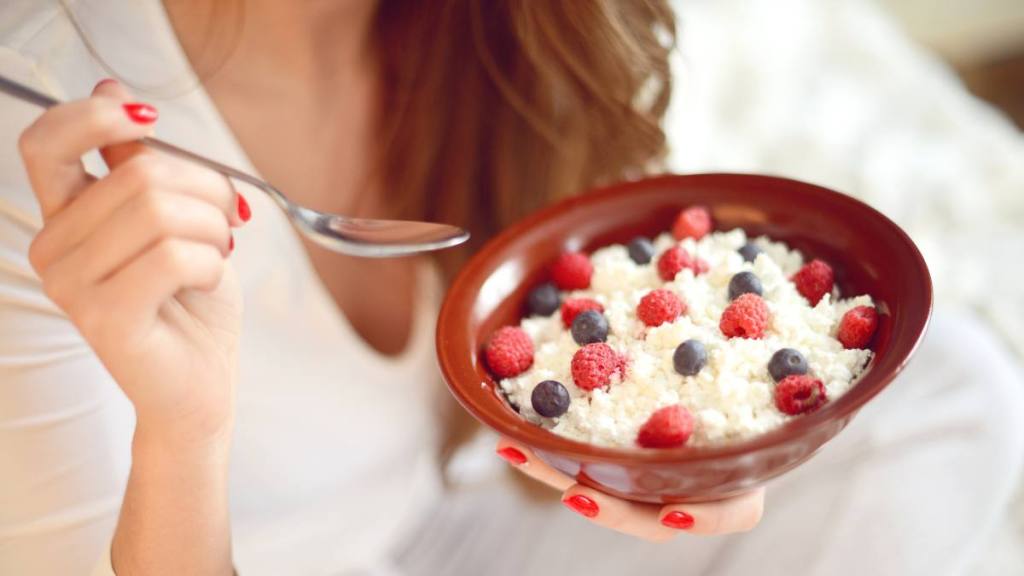 cottage cheese trend: woman eats cottage cheese with berries