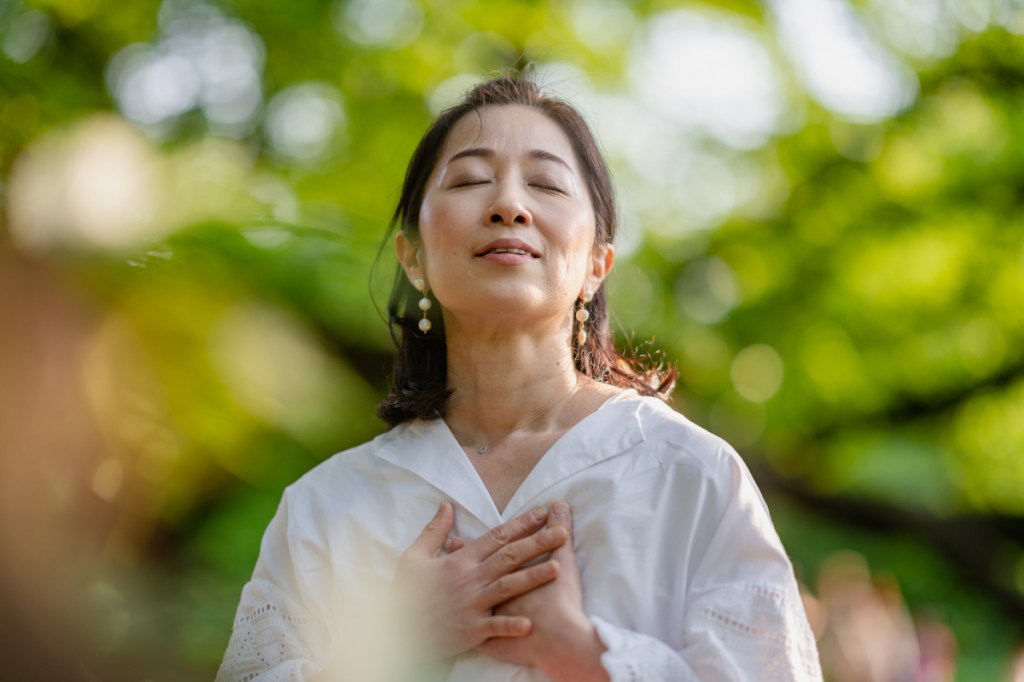 Woman practicing hopefulness by meditating outside