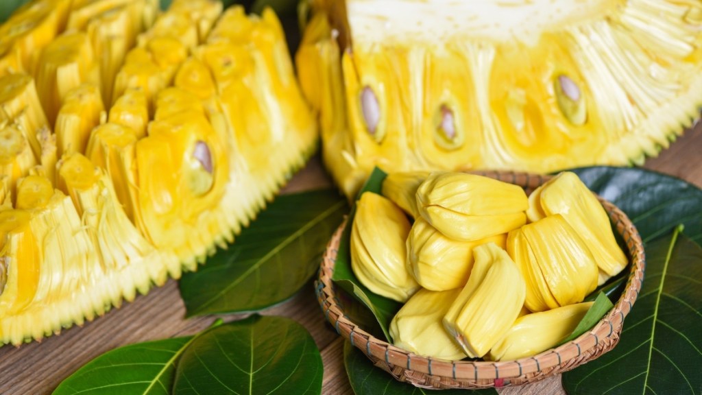 Jackfruit flesh in a bowl and on a table with a green leaf