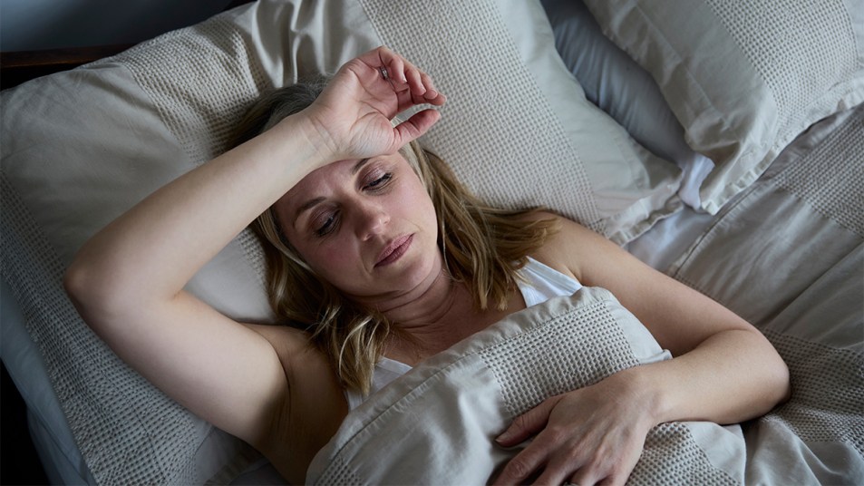 Woman dealing with night sweats in bed