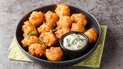 air fryer hush puppies: hush puppies in black bowl with dipping sauce