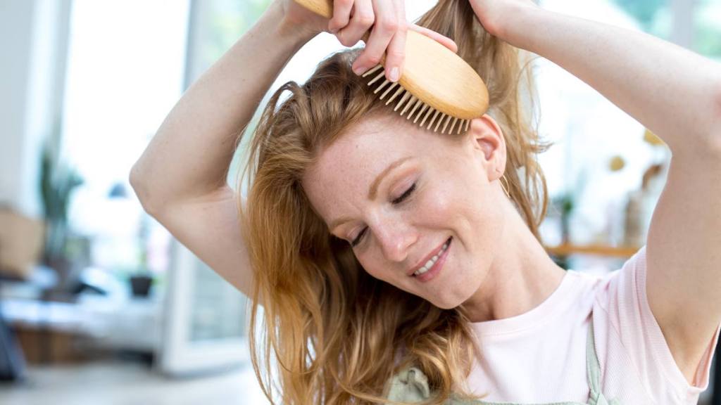 woman brushing hair; boost energy