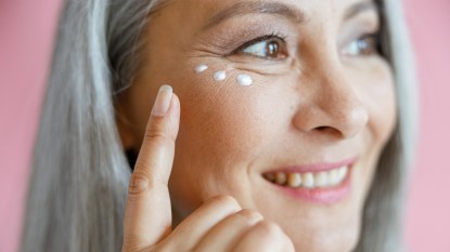 Mature woman applying eye cream
