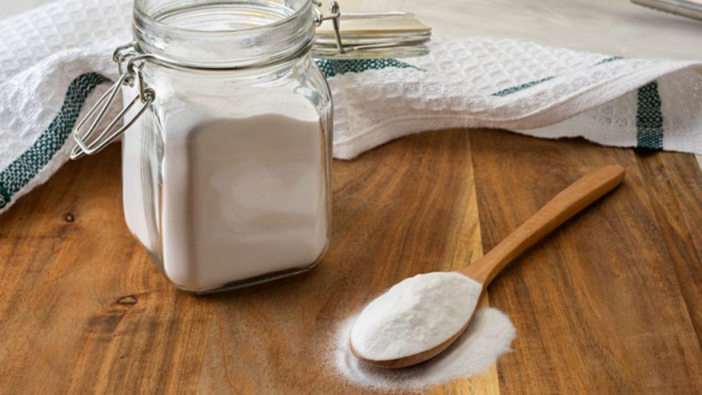 overnight cleaning hacks: baking soda in jar next to wooden spoon