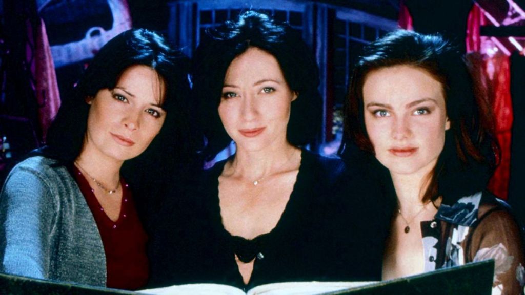 Three women with heads together; facts about charmed