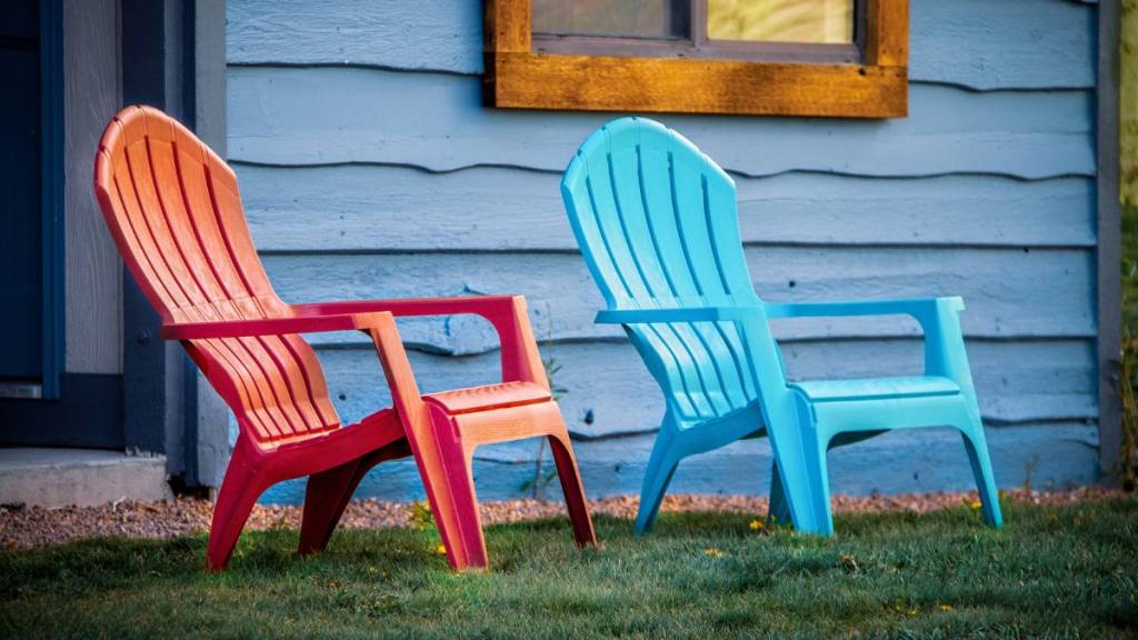 uses for shaving cream: Close-up of red and turquoise arondiack chairs sitting outside blue wooden cabin door on grass.
