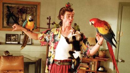 (Ace Ventura: Pet Detective) a man standing with animals on his arms