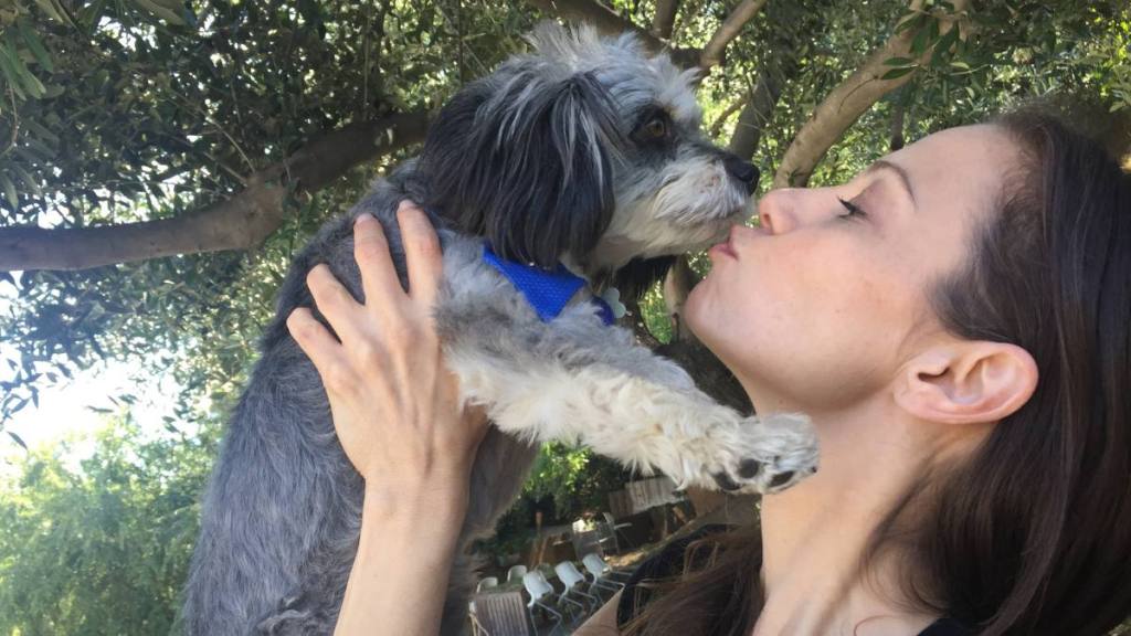 woman kissing a dog; Tamara with her dog