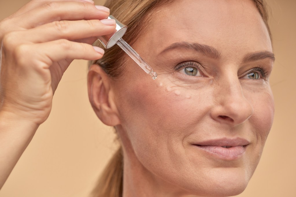 Woman applying one of the best vitamin C serums
