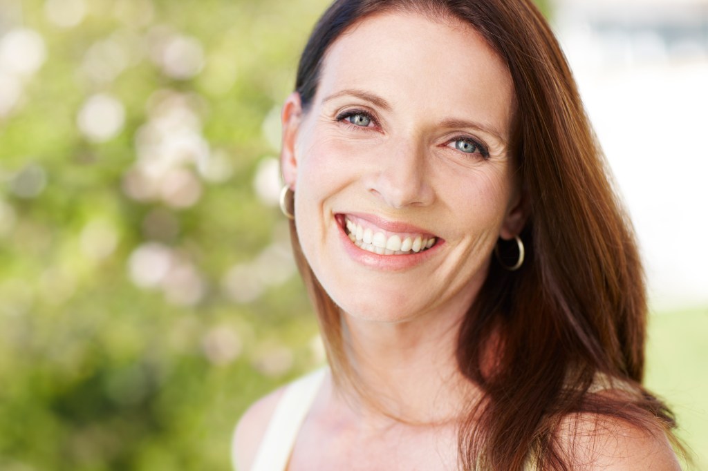Woman smiling with flawless skin, which can be achieved with a chemical peel before and after