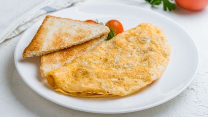 microwave omelette on a plate with toast and tomatoes