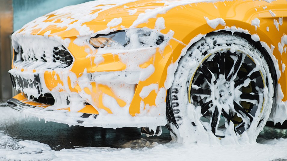 Yellow car covered with dish soapy water