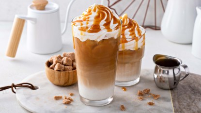 Iced caramel latte topped with whipped cream and caramel sauce,