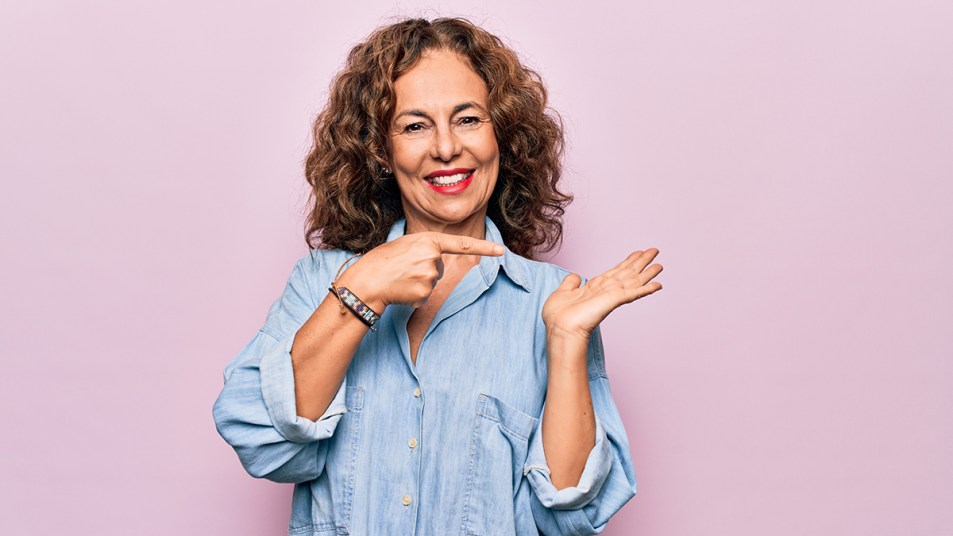 Middle aged woman pointing to her palm that's got no self-tanner on it