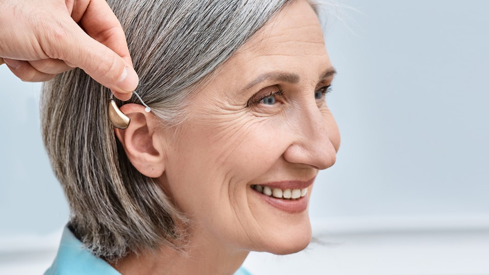 Woman receiving a hearing aid during a fitting