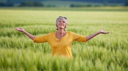 Woman in a field finally free from worrying about money