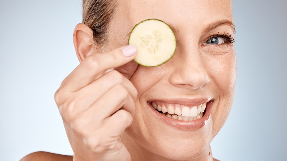 Woman looking younger than her age holding up a cucumber