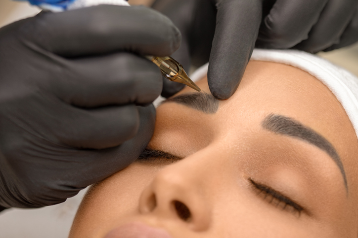 Woman receiving microblading treatment for sparse eyebrows.