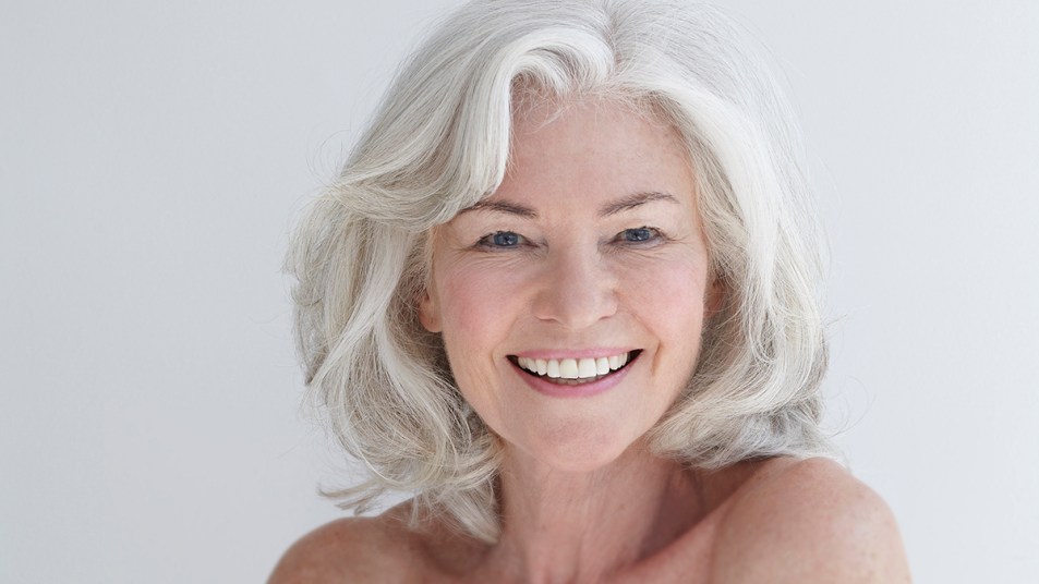 An older woman smiling because she styled her thinning hair in a way that made it look thicker