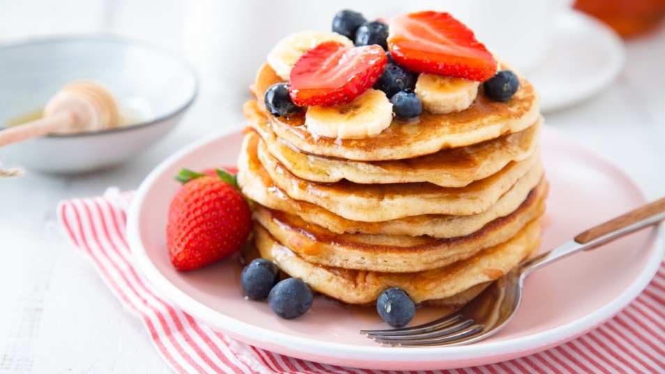 stack of pancakes with berries and bananas