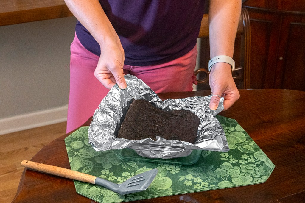 uses for aluminum foil: Woman lifting brownies out of dish
