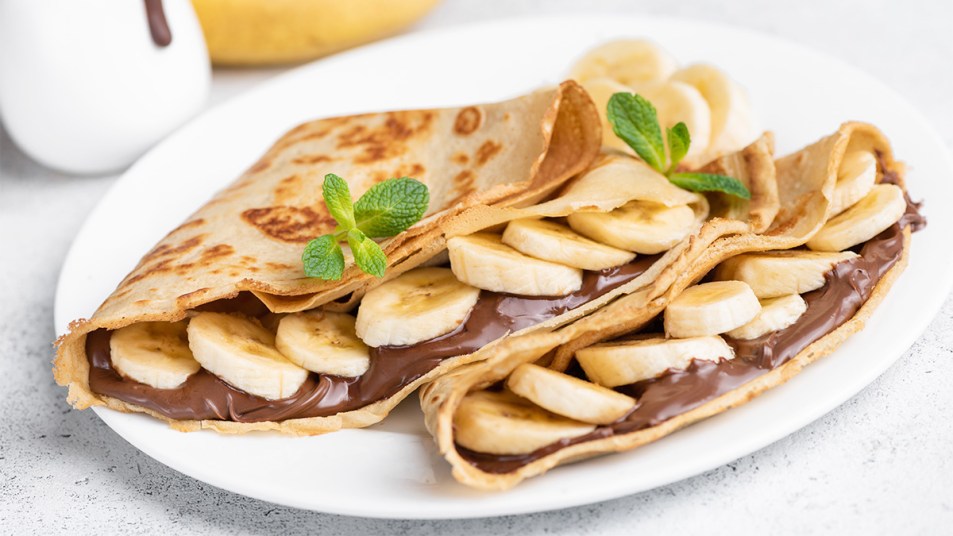 Banana-nutella stuffed crepes as part of a guide on how to make the French dish using pancake mix