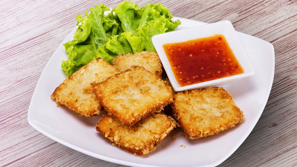 Crispy rice on a plate with a dipping sauce