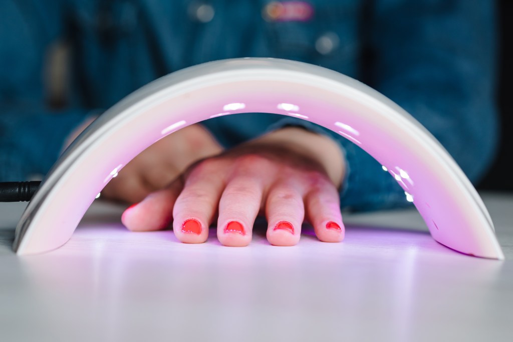 UV lamp with light for drying nails that are painted red