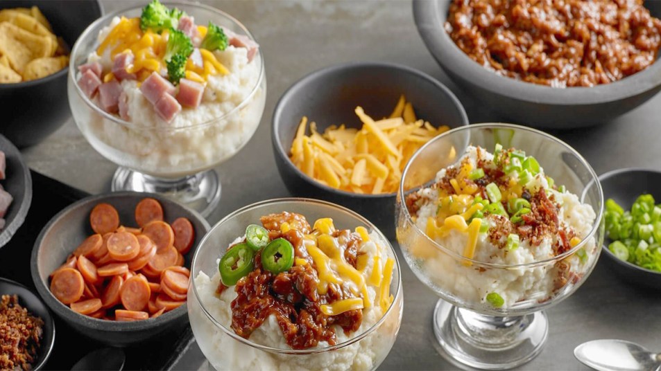 A mashed potato bar with mashed potatoes and various toppings