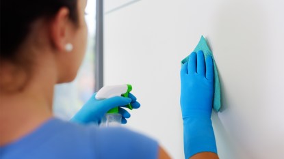 woman cleaning a dry erase board of permanent marker
