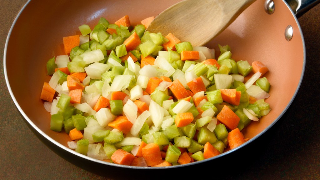 Soffritto (a mixture of onions, celery and carrots) cooking in a skillet